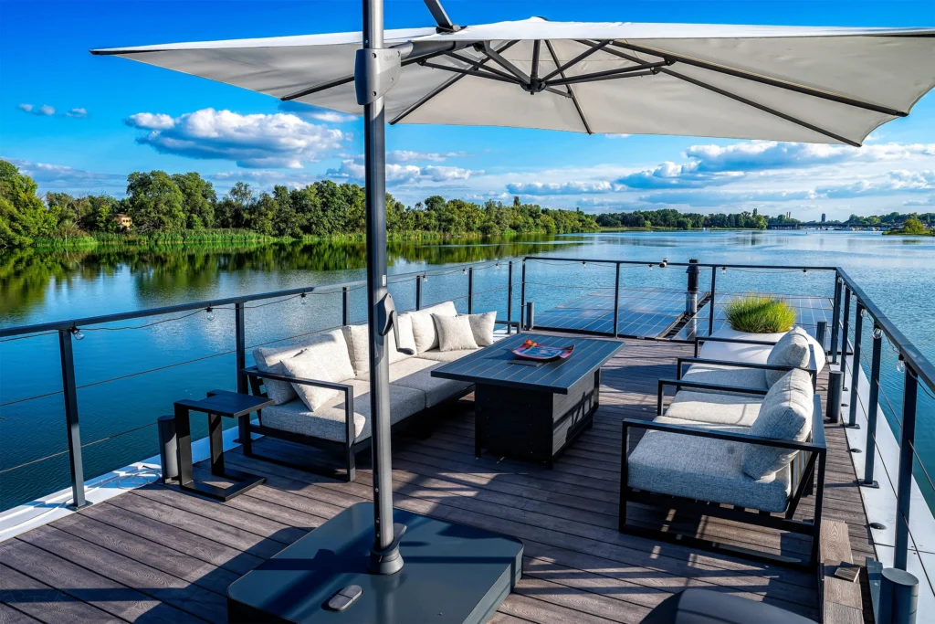 Dachterrasse des Hausboots mit Lounge-Sofa, Sonnenschirm und Blick auf die Havelseen