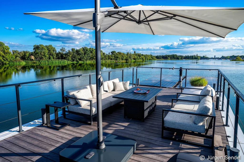 Dachterrasse des Hausboots mit Lounge-Sofa, Sonnenschirm und Blick auf die Havelseen